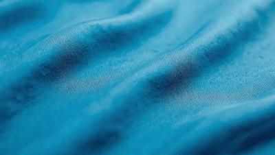 The primary subject of the image is a blue fabric, which appears to be a piece of cloth or a curtain. The setting is a room with a blue background, and the visual style is a close-up of the fabric. The colors and mood of the image are predominantly blue, creating a calm and serene atmosphere.