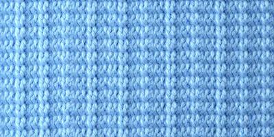 The primary subject of the image is a blue knitted fabric. The setting is a close-up of the knitted fabric, showcasing its intricate pattern. The visual style is a detailed, up-close view of the knitted fabric. The colors and mood of the image are predominantly blue, creating a calm and soothing atmosphere.