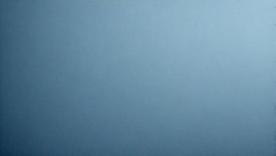 The primary subject of the image is a large, empty blue sky. The setting is a vast, open space with no visible landmarks or objects. The visual style is a natural, untouched landscape. The colors and mood are predominantly blue, creating a calm and serene atmosphere.