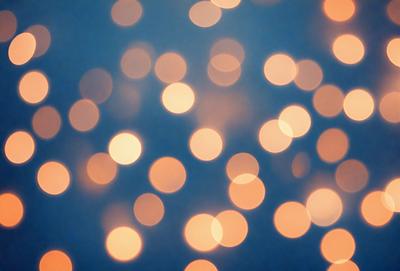 The primary subject of the image is a large number of bright, colorful lights. The lights are scattered throughout the scene, creating a visually striking and vibrant atmosphere. The setting appears to be a dark background, which further emphasizes the brightness of the lights. The visual style of the image is a combination of photo and digital art, as it captures the essence of a light show or a similar event. The colors and mood of the image are predominantly warm and inviting, with the lights creating a sense