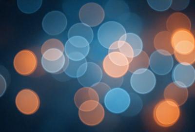 The primary subject of the image is a brightly lit, colorful background featuring a pattern of circles. The setting appears to be a dark room, with the circles creating a visually striking and vibrant atmosphere. The visual style of the image is a combination of a photo and digital art, as it captures the essence of a colorful, light-filled environment. The colors and mood of the image are predominantly warm and inviting, with the bright lights and circles creating a sense of energy and liveliness.