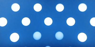 The primary subject of the image is a blue background with a pattern of white circles. The setting appears to be a dark room, and the visual style is a digital art or illustration. The dominant colors are blue and white, creating a calm and serene atmosphere.