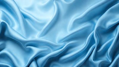 The primary subject of the image is a blue fabric, which appears to be a piece of silk. The setting is a blue background, which complements the blue fabric. The visual style is a close-up of the fabric, showcasing its texture and details. The colors and mood of the image are predominantly blue, creating a calm and serene atmosphere.
