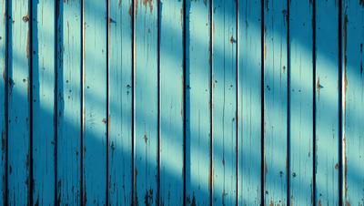 The primary subject of the image is a blue wall with a wooden texture. The setting is a room with a blue wall, and the visual style is a photo. The dominant colors are blue and white, creating a calm and serene atmosphere.
