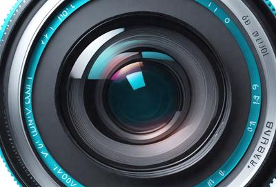 Primary subject: Camera lens
Setting/background: Black background
Visual style: Photo
Colors and mood: Blue and black