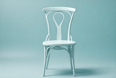 The primary subject of the image is a white chair with a unique design. The chair is placed on a blue surface, which serves as the setting or background. The visual style of the image is a photo, capturing the chair's details and colors. The dominant colors in the image are white and blue, creating a clean and calming atmosphere.