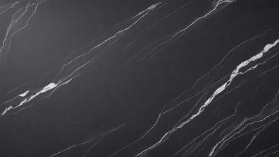 The primary subject of the image is a black marble countertop. The setting is a kitchen, with the countertop being the main focus of the scene. The visual style is a photo, capturing the natural texture and appearance of the marble countertop. The colors and mood of the image are predominantly dark, with the black marble providing a striking contrast against the dark background.