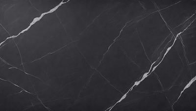 The primary subject of the image is a black marble countertop. The setting is a kitchen, with the countertop being the main focus of the scene. The visual style is a photo, capturing the natural texture and appearance of the marble countertop. The colors and mood of the image are predominantly dark, with the black marble providing a striking contrast against the lighter background.