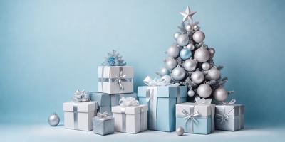 The primary subject of the image is a Christmas tree, which is adorned with silver ornaments and presents. The tree is placed on a blue surface, which serves as the setting or background. The visual style of the image is a photo, capturing the festive atmosphere of the holiday season. The dominant colors in the image are silver and blue, creating a warm and celebratory mood.