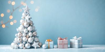 The primary subject of the image is a Christmas tree decorated with ornaments and a bow. The tree is placed on a blue surface, which serves as the setting or background. The visual style of the image is a photo, capturing the festive atmosphere of the holiday season. The dominant colors in the image are blue and white, creating a calm and serene mood.