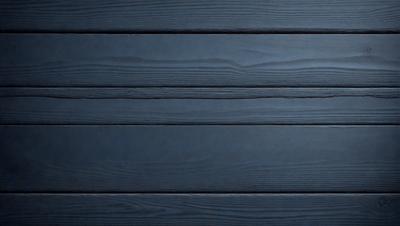 The primary subject of the image is a wooden wall. The setting is a dark room with a blue wall, which creates a moody atmosphere. The visual style is a close-up of the wooden wall, showcasing its texture and details. The colors and mood of the image are predominantly dark, with the blue wall providing a subtle contrast.