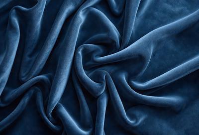 The primary subject of the image is a blue fabric, which is the main object, scene, or focus of the image. The setting or background is a blue surface, which adds to the overall atmosphere. The visual style of the image is a close-up of the blue fabric, showcasing its texture and pattern. The colors and mood of the image are predominantly blue, creating a calm and serene atmosphere.