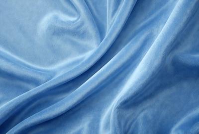 The primary subject of the image is a blue fabric, possibly a piece of cloth or a curtain. The setting is a room with a blue background, which creates a cohesive and visually appealing environment. The visual style of the image is a close-up of the blue fabric, showcasing its texture and details. The colors and mood of the image are predominantly blue, giving it a calm and serene atmosphere.
