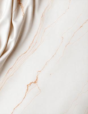The primary subject of the image is a marble countertop with a white cloth draped over it. The setting is a kitchen or a similar environment, as the countertop is a common surface in such spaces. The visual style is a close-up of the marble countertop, showcasing its texture and the cloth draped over it. The colors and mood of the image are predominantly white and neutral, giving it a clean and elegant appearance.