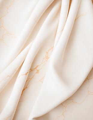 The primary subject of the image is a white sheet of fabric. The setting is a white background, which creates a clean and minimalist appearance. The visual style is a close-up of the fabric, showcasing its texture and details. The colors and mood of the image are predominantly white, giving it a calm and serene atmosphere.