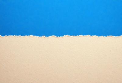 The primary subject of the image is a white surface, which appears to be a piece of paper or a canvas. The setting is a blue sky, creating a contrasting backdrop for the white surface. The visual style is a close-up of the white surface, showcasing its texture and details. The colors and mood of the image are predominantly white and blue, giving it a calm and serene atmosphere.