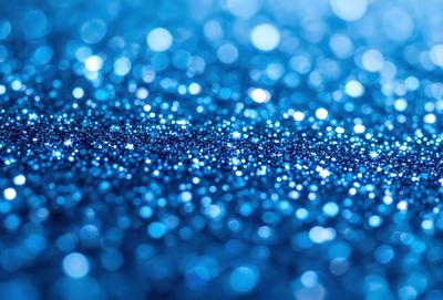 The primary subject of the image is a blue surface, possibly a wall or a piece of fabric, with a pattern of blue glitter or sparkles. The setting appears to be indoors, with the blue surface being the main focus of the image. The visual style is a close-up of the blue surface, showcasing the glittery pattern. The colors and mood of the image are predominantly blue, with a sense of shine and sparkle from the glittery pattern.