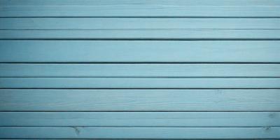 The primary subject of the image is a blue wooden wall. The setting is a room with a blue wooden wall, and the visual style is a photo. The dominant colors are blue and white, creating a calm and serene atmosphere.