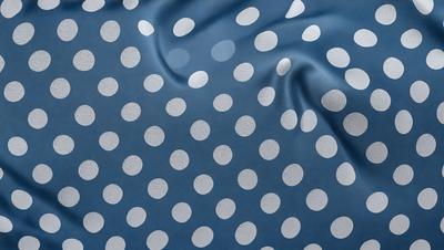 The primary subject of the image is a blue cloth with white polka dots. The setting is a room with a blue background. The visual style is a close-up of the cloth, showcasing the polka dots. The colors and mood of the image are predominantly blue and white, creating a calm and soothing atmosphere.