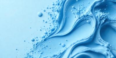 The primary subject of the image is a blue liquid, possibly water or a blue substance, with white bubbles floating in it. The setting is a white background, which provides a clean and uncluttered appearance. The visual style is a close-up of the blue liquid, showcasing the bubbles and their movement. The colors and mood of the image are predominantly blue and white, creating a calm and serene atmosphere.