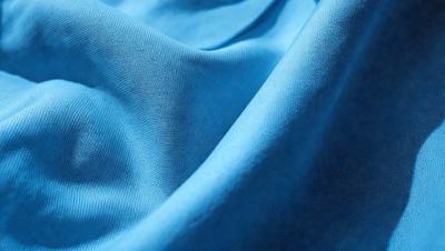 The primary subject of the image is a blue fabric, which is the main object, scene, or focus of the image. The setting or background is a blue cloth, and the visual style is a photo. The dominant colors and overall atmosphere are blue and calm.