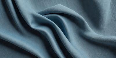 The primary subject of the image is a blue fabric, which is the main object, scene, or focus of the image. The setting or background is a dark blue surface, and the visual style is a photo. The colors and mood of the image are predominantly dark blue, creating a calm and serene atmosphere.