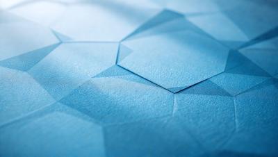 The primary subject of the image is a blue piece of paper with a geometric pattern on it. The paper is placed on a blue surface, which could be a table or a wall. The visual style of the image is a close-up of the paper, showcasing the intricate pattern and design. The colors and mood of the image are predominantly blue, creating a calm and serene atmosphere.
