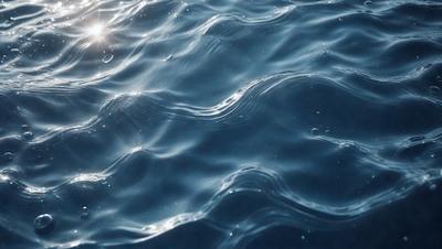 The primary subject of the image is the ocean, with its waves and ripples. The setting is the open water, and the visual style is a photo. The colors and mood of the image are predominantly blue, creating a serene and calming atmosphere.