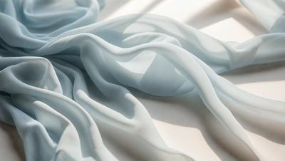 The primary subject of the image is a blue sheet of fabric, which is the main object, scene, or focus of the image. The setting is a white surface, which serves as the background. The visual style is a photo, as the image is a close-up of the blue fabric. The dominant colors are blue and white, creating a calm and serene atmosphere.