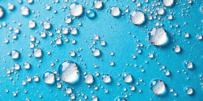 The primary subject of the image is a close-up of a blue surface with numerous small bubbles on it. The setting appears to be a blue background, and the visual style is a close-up of the bubbles on the surface. The colors and mood of the image are predominantly blue, with the bubbles creating a sense of depth and texture.