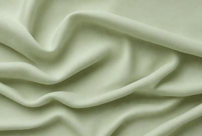 The primary subject of the image is a piece of green fabric, which is the main object, scene, or focus of the image. The setting or background of the image is a green surface, which provides a contrasting backdrop for the fabric. The visual style of the image is a close-up of the fabric, showcasing its texture and details. The colors and mood of the image are predominantly green, creating a calm and soothing atmosphere.