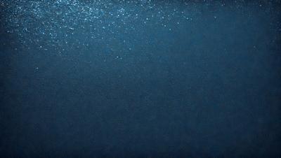 The primary subject of the image is a large body of water, which appears to be a deep blue ocean. The setting is underwater, with the water surface visible. The visual style of the image is a photo, capturing the beauty of the ocean. The dominant colors are blue and black, creating a serene and calming atmosphere.