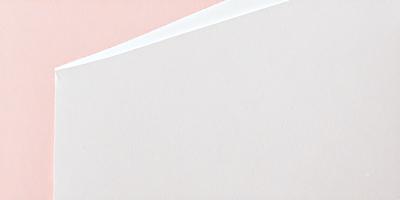 The primary subject of the image is a piece of paper with a pink background. The setting is a simple, clean environment, with no visible backdrop or surface. The visual style is a close-up of the paper, showcasing its texture and color. The colors and mood of the image are predominantly pink, creating a warm and inviting atmosphere.