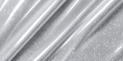 The primary subject of the image is a silver metallic fabric, which appears to be a shiny, metallic-looking material. The setting is a close-up view of the fabric, showcasing its unique texture and appearance. The visual style of the image is a close-up, focusing on the details of the fabric. The colors and mood of the image are predominantly silver and metallic, giving it a sleek and modern look.
