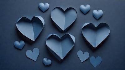 The primary subject of the image is a collection of blue heart-shaped cutouts. These heart-shaped cutouts are arranged on a blue wall, creating a visually appealing display. The setting is indoors, with the blue wall serving as the background. The visual style of the image is a combination of digital art and illustration, as the hearts are created using a digital medium. The dominant colors in the image are blue, which is the color of the hearts and the wall, and white, which is the color of