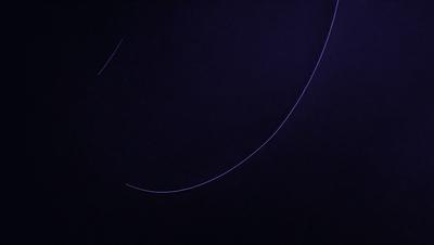 The primary subject of the image is a purple background with a blue line or curve. The setting appears to be a dark, possibly futuristic environment. The visual style is a combination of digital art and illustration, creating a unique and intriguing atmosphere. The colors and mood convey a sense of mystery and depth, inviting the viewer to explore the scene further.