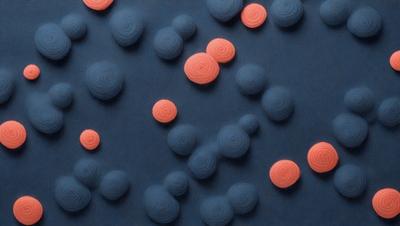 The primary subject of the image is a blue surface with a pattern of red and orange balls scattered across it. The setting appears to be a dark room, and the visual style is a combination of digital art and illustration. The dominant colors in the image are blue, red, and orange, creating a vibrant and lively atmosphere.