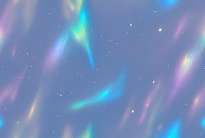 The primary subject of the image is a blue sky filled with colorful, swirling, and flowing patterns. The setting is a night sky, and the visual style appears to be a combination of a photo and digital art. The colors and mood of the image are vibrant and lively, creating a sense of wonder and exploration.