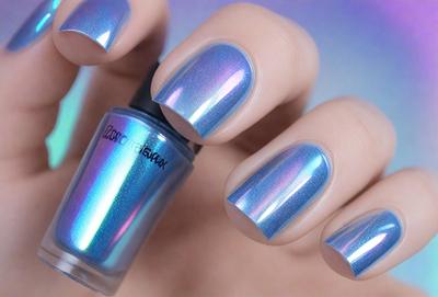 The primary subject of the image is a person's hand holding a bottle of nail polish. The hand is positioned in the foreground, while the bottle of nail polish is in the background. The setting appears to be a room with a purple background. The visual style is a close-up of the hand and the bottle, with a focus on the nail polish. The colors and mood of the image are predominantly purple, creating a calm and soothing atmosphere.