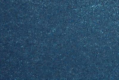 The primary subject of the image is a blue surface, which appears to be a wall or a piece of fabric. The setting is a dark room, and the visual style is a close-up of the blue surface. The colors and mood of the image are predominantly dark and moody, with the blue surface being the main focus.