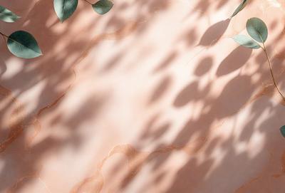 The primary subject of the image is a wall with a pink surface. The setting is a room with a tree branch and leaves visible in the background. The visual style is a photo, and the colors and mood are warm and inviting.