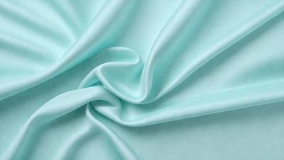 The primary subject of the image is a piece of blue fabric, which is the main object, scene, or focus of the image. The setting or background of the image is a blue surface, which adds to the overall atmosphere. The visual style of the image is a photo, as it captures the fabric's texture and details. The colors and mood of the image are predominantly blue, creating a calm and serene atmosphere.