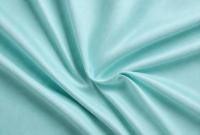The primary subject of the image is a piece of blue fabric, which is the main object, scene, or focus of the image. The setting or background of the image is a blue cloth, which is the environment, backdrop, or surface visible in the image. The visual style of the image is a photo, as it is a real-life photograph of the blue fabric. The dominant colors in the image are blue, which creates a calm and soothing atmosphere.