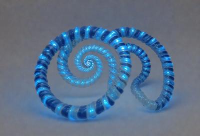 The primary subject of the image is a pair of blue spiral earrings. The earrings are made of glass and have a spiral design. The setting is a white background, which provides a clean and minimalist look to the image. The visual style is a close-up of the earrings, showcasing their intricate details. The colors and mood of the image are predominantly blue, giving the earrings a cool and elegant appearance.