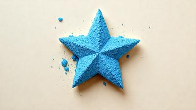 The primary subject of the image is a blue star made of powdered sugar. The setting is a white background, and the visual style appears to be a close-up of the star. The colors and mood of the image are predominantly blue and calm, with the star being the main focus of the composition.