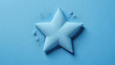 The primary subject of the image is a blue star made of sugar. The setting is a blue background, and the visual style is a close-up of the sugar star. The colors and mood of the image are predominantly blue, creating a calm and serene atmosphere.