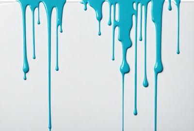 The primary subject of the image is a white surface with blue drips of paint on it. The setting is a white wall, and the visual style is a close-up of the drips. The colors and mood of the image are predominantly blue, creating a calm and serene atmosphere.