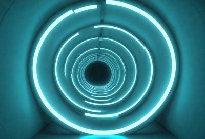 The primary subject of the image is a tunnel with a blue light illuminating it. The setting is a dark room, and the visual style appears to be a digital art or illustration. The dominant colors are blue and white, creating a calm and serene atmosphere.
