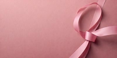 The primary subject of the image is a pink ribbon. The ribbon is wrapped around a pink surface, which could be a piece of paper or a wall. The setting appears to be indoors, and the visual style is a close-up of the pink ribbon. The colors and mood of the image are predominantly pink, creating a warm and inviting atmosphere.