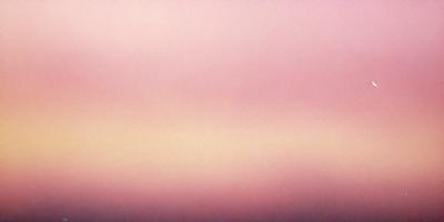 The primary subject of the image is a pink sky, which creates a serene and calming atmosphere. The setting is a cloudy sky, and the visual style appears to be a photo. The dominant colors are pink and purple, which contribute to the overall mood of the scene.